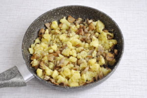 Картофель разомнем вилкой, соединим лук и грибы